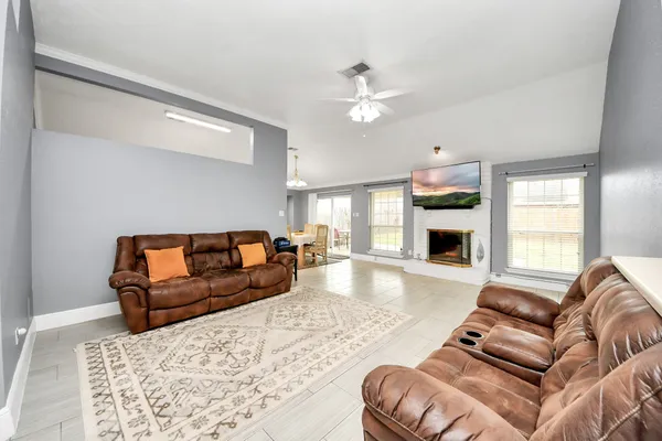 a living room with furniture a fireplace and a flat screen tv