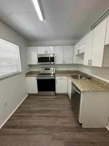 a kitchen with stainless steel appliances granite countertop a stove top oven a sink dishwasher and a refrigerator