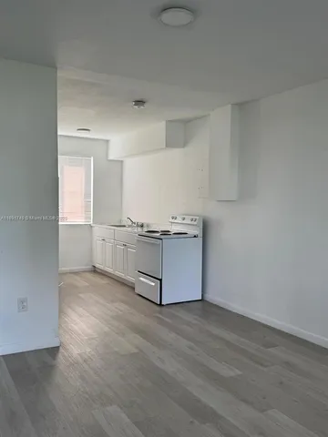 a kitchen with stainless steel appliances cabinets and wooden floor