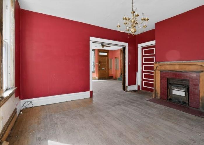 1156 Pemberton Street Pittsburgh, PA 15212 - Photo 6 of 20 an empty room with a fireplace and chandelier