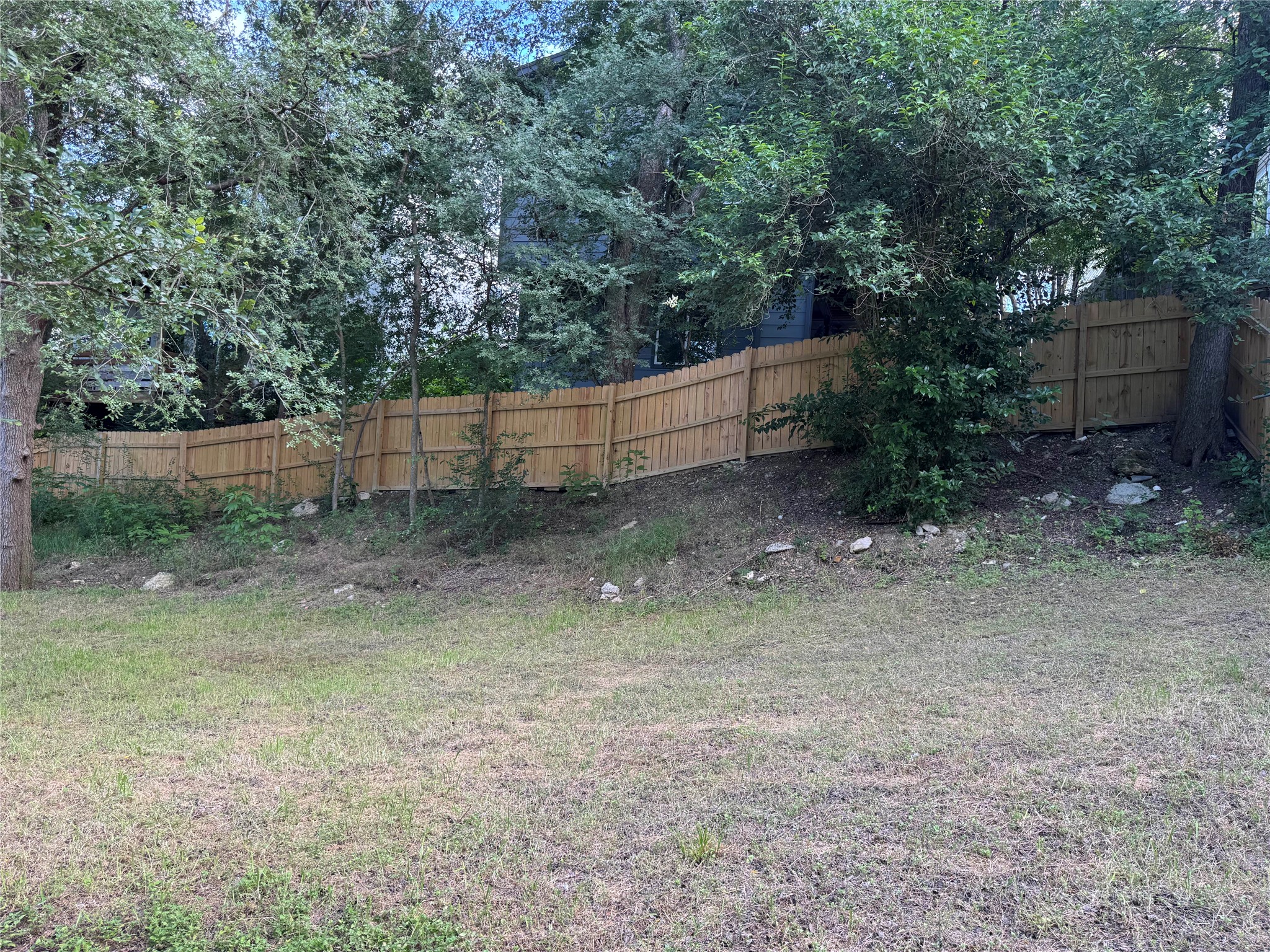 5007 Heflin Lane Austin, TX 78721 - Photo 18 of 25 A well-maintained wooden privacy fence defines the boundary of a lush, verdant yard.