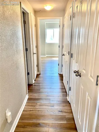 a view of a hallway with wooden floor and staircase