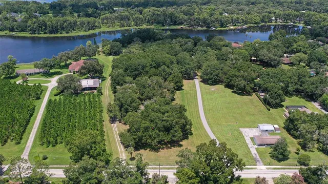 an aerial view of a house with a yard and lake view