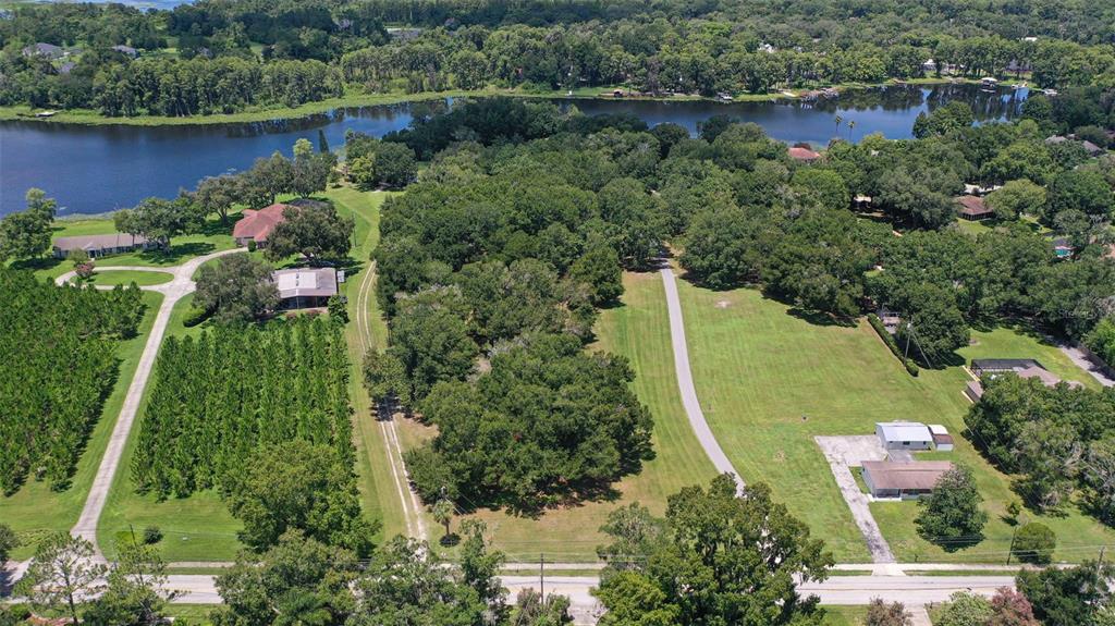 an aerial view of a house with a yard and lake view