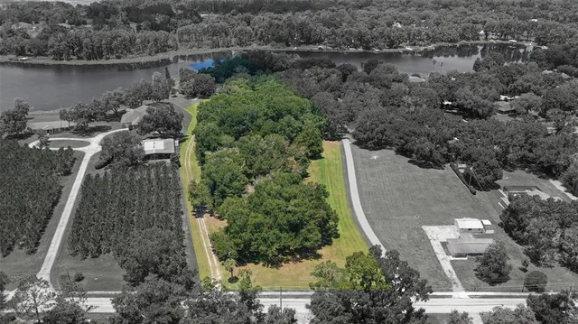 an aerial view of a house with a yard and lake view