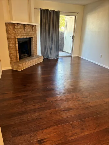 an empty room with wooden floor and fireplace