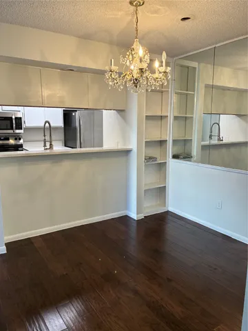 a view of a kitchen with wooden floor and a large window