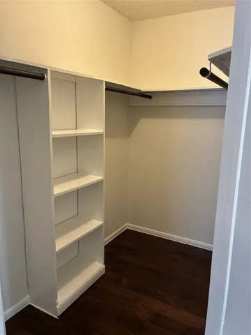 a view of walk in closet with empty racks