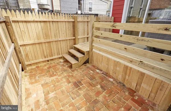 a view of a balcony with wooden floor and fence