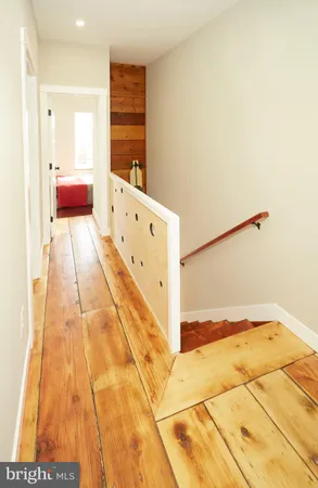 a bedroom with a bed and a wooden floor