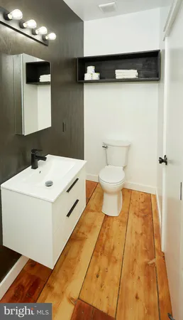 a bathroom with a sink toilet and mirror