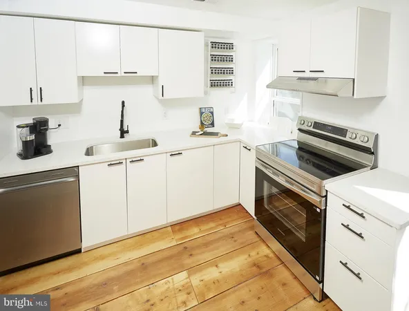 a kitchen with cabinets appliances and a window