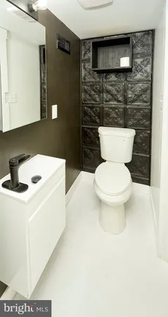a bathroom with a toilet a sink and a mirror