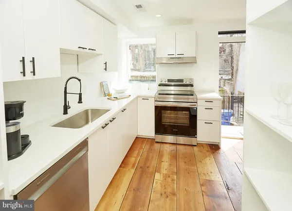 a kitchen with a sink a stove and cabinets