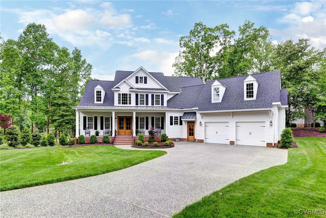 a front view of a house with a garden and trees
