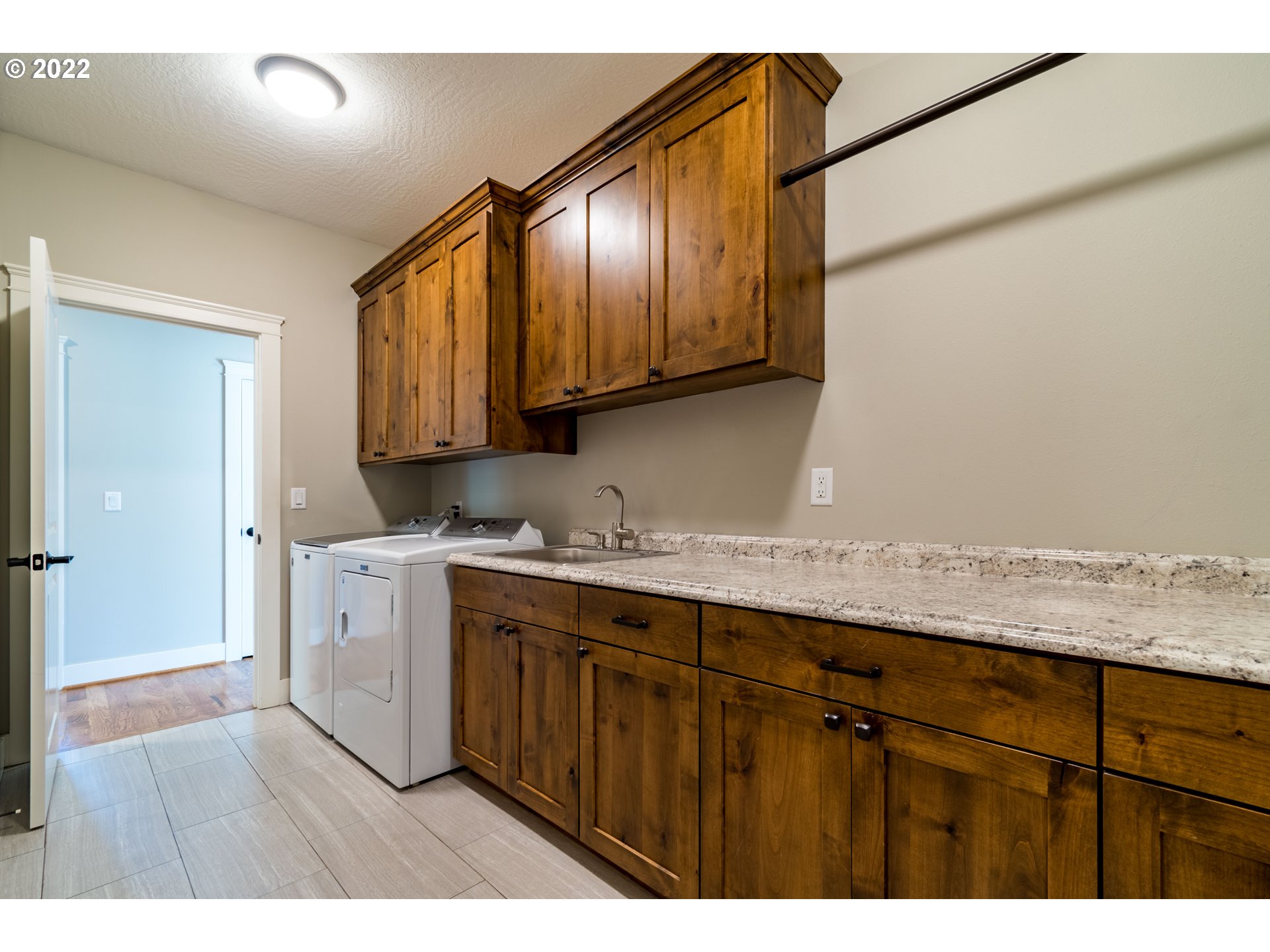 6074 Graystone Loop Springfield, OR 97478 - Photo 25 of 32 a kitchen with stainless steel appliances granite countertop a sink a stove and wooden cabinets