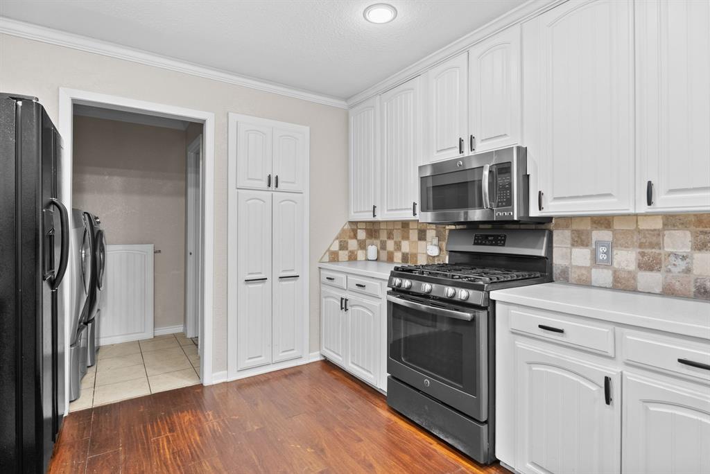 3217 Libbie Street Tyler, TX 75707 - Photo 10 of 35 a kitchen with cabinets stainless steel appliances and wooden floor