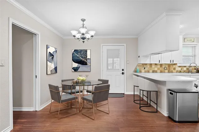 a kitchen with cabinets stainless steel appliances and wooden floor