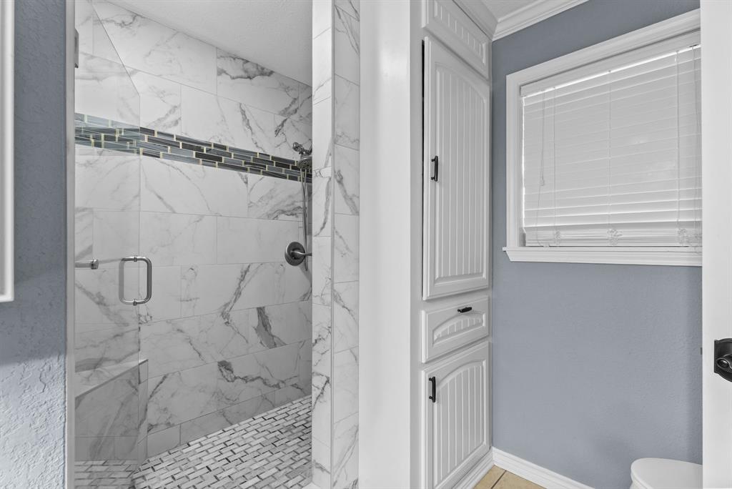 3217 Libbie Street Tyler, TX 75707 - Photo 20 of 35 a bathroom with a glass shower door