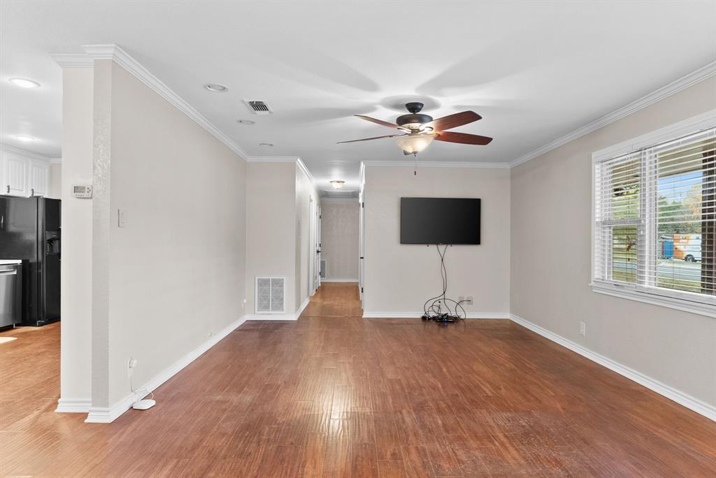 3217 Libbie Street Tyler, TX 75707 - Photo 7 of 35 a view of a livingroom with a flat screen tv wooden floor and a ceiling fan
