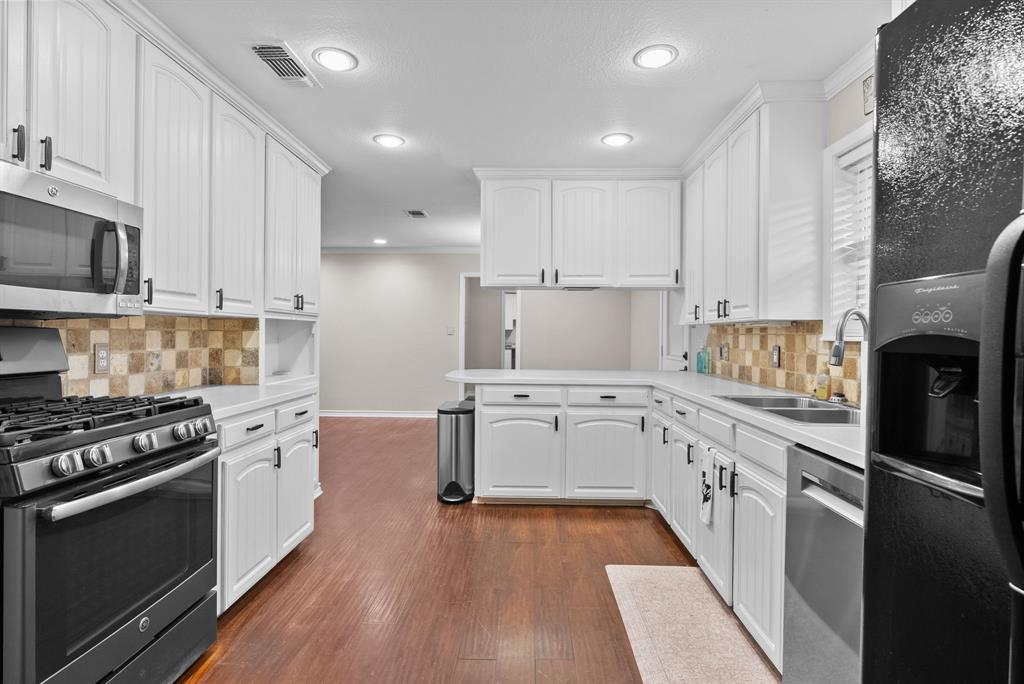 3217 Libbie Street Tyler, TX 75707 - Photo 9 of 35 a kitchen with granite countertop a stove top oven sink and cabinets