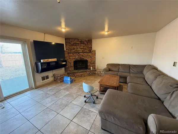 a living room with furniture a flat screen tv and a fireplace