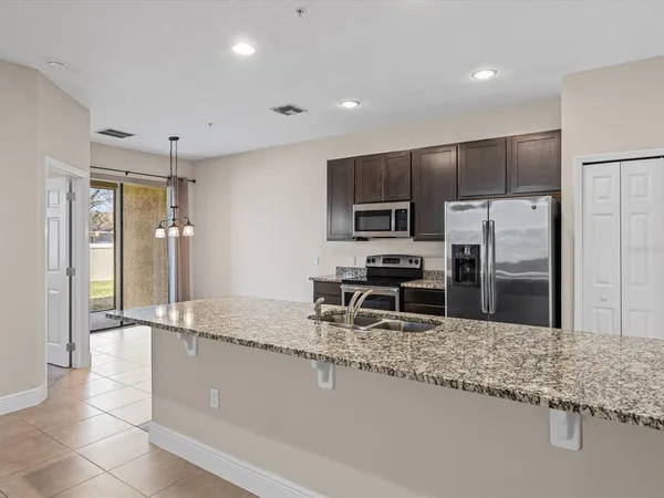 a kitchen with stainless steel appliances granite countertop a sink refrigerator and microwave