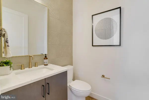 a bathroom with a toilet sink vanity and mirror
