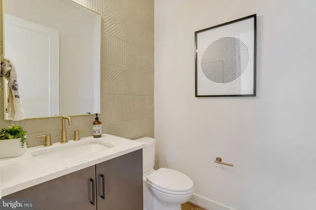 a bathroom with a toilet sink vanity and mirror
