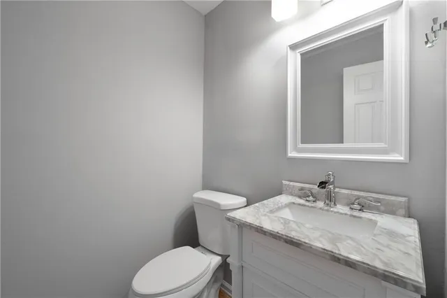 a bathroom with a granite countertop toilet sink and mirror