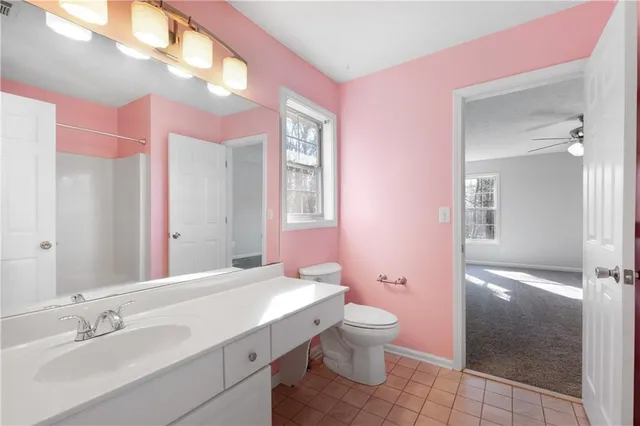 a bathroom with a sink vanity granite and toilet