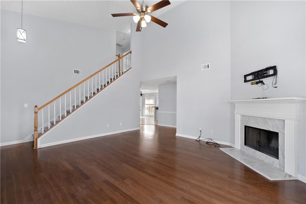 4240 Berkeley Mill Lane Duluth, GA 30096 - Photo 6 of 32 a view of an empty room with wooden floor and a fireplace