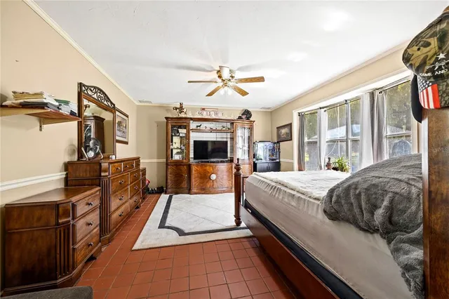 a bedroom with a bed and a flat tv screen on the dresser