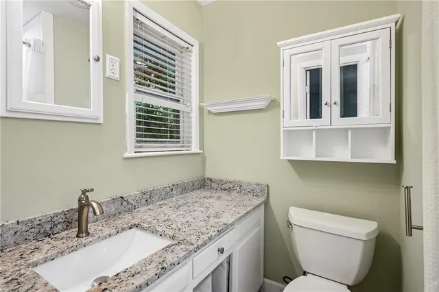 a bathroom with a granite countertop sink toilet and shower