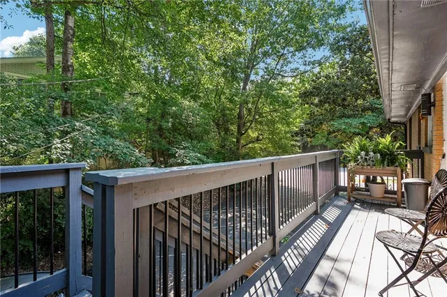 a balcony with wooden floor and trees in the back