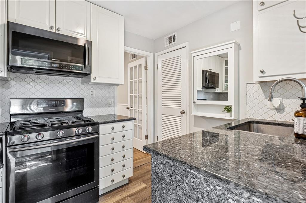 1010 Scott Boulevard, Unit A6 Decatur, GA 30030 - Photo 7 of 26 a kitchen with stainless steel appliances granite countertop a stove microwave and sink