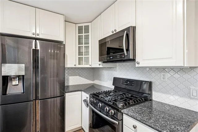 a kitchen with stainless steel appliances granite countertop a refrigerator stove top oven and sink