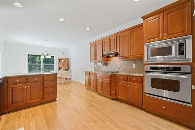 a kitchen with stainless steel appliances granite countertop a stove a sink dishwasher and a microwave oven with cabinets