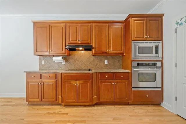 a kitchen with granite countertop cabinets stainless steel appliances granite counter tops and a wooden floors