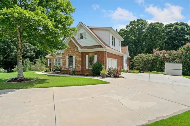 a front view of a house with a yard and trees