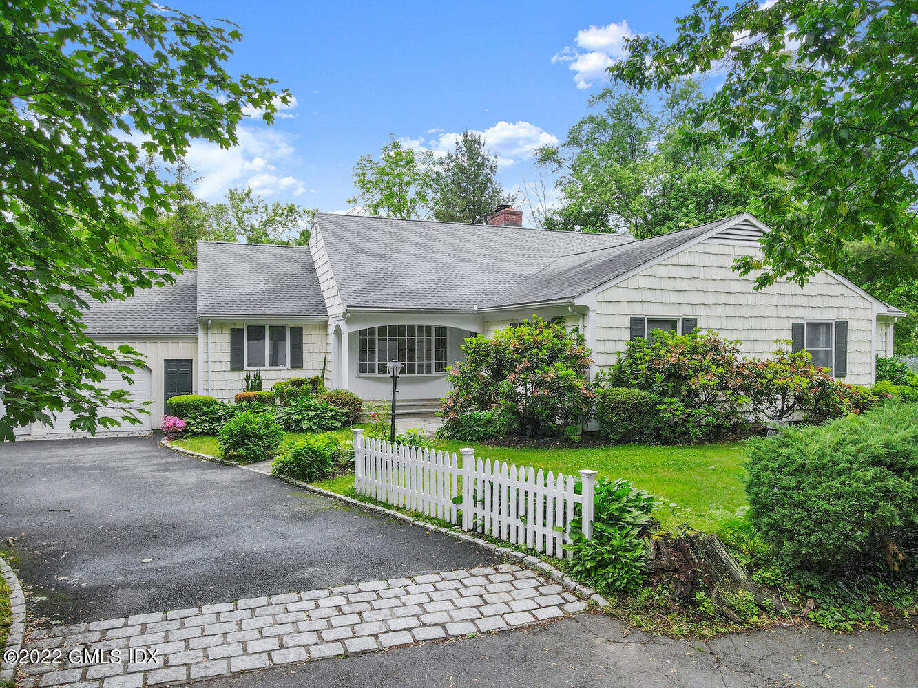 a front view of a house with a yard and potted plants