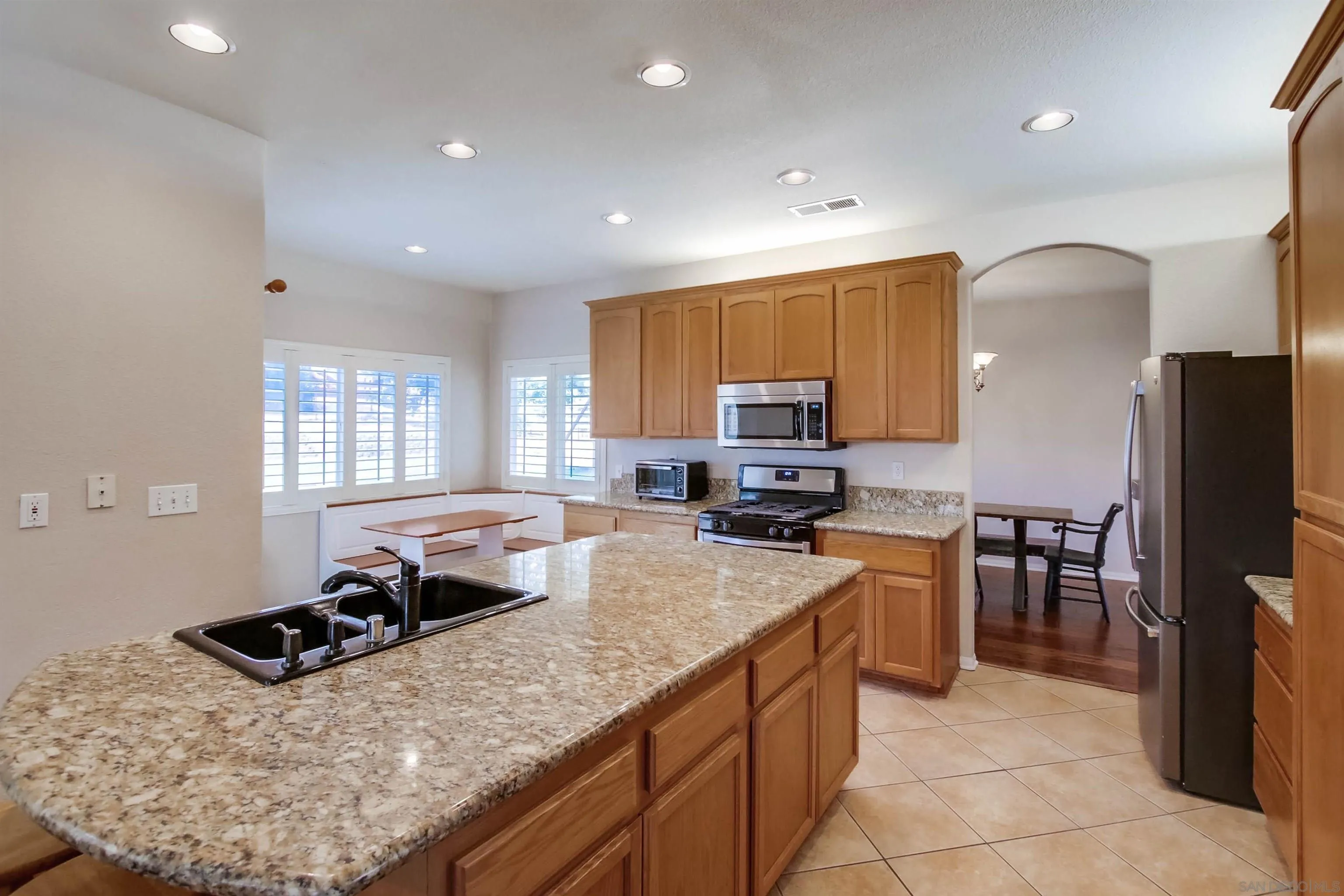 16304 Dartolo Road Ramona, CA 92065 - Photo 17 of 64 a kitchen with a stove a sink a refrigerator and cabinets