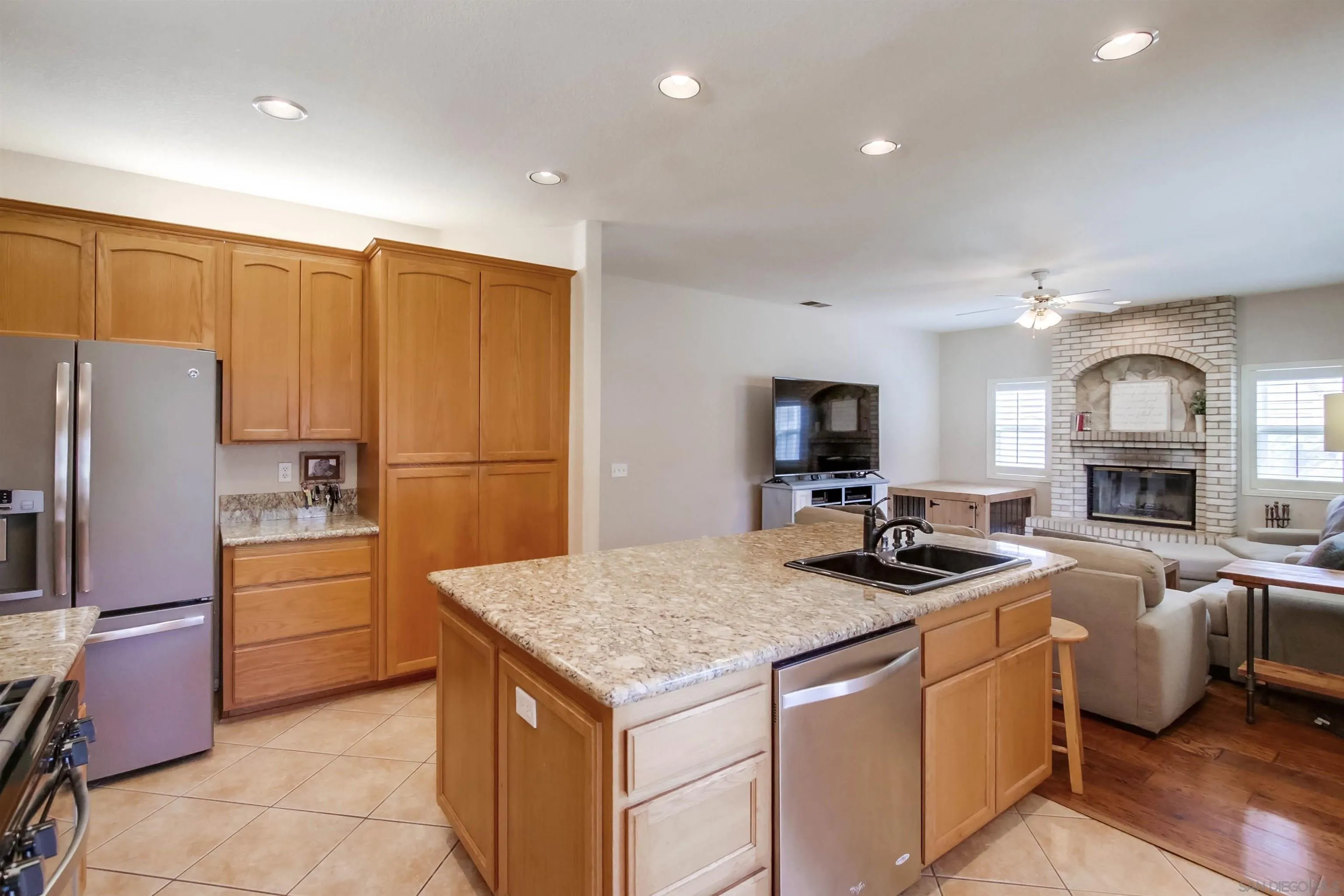 16304 Dartolo Road Ramona, CA 92065 - Photo 21 of 64 a kitchen that has a lot of cabinets a sink a stove and a refrigerator