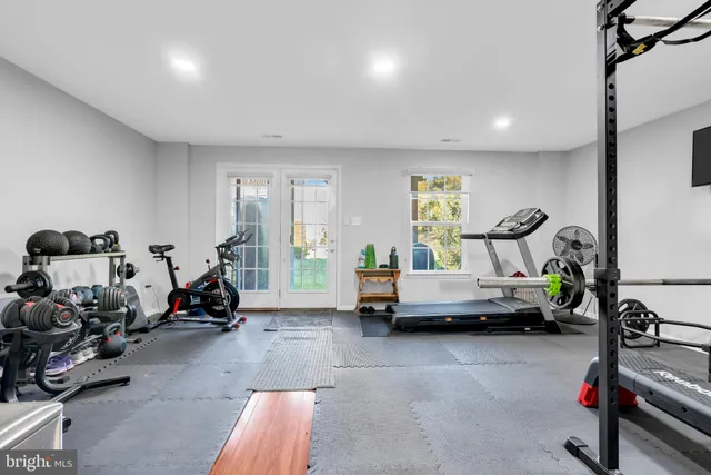 a living room with furniture and a gym cycle