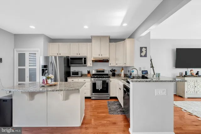 a kitchen with kitchen island a sink stove and refrigerator
