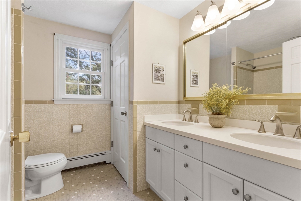 7 Countryside Road Natick, MA 01760 - Photo 25 of 37 a bathroom with a granite countertop toilet sink and a mirror