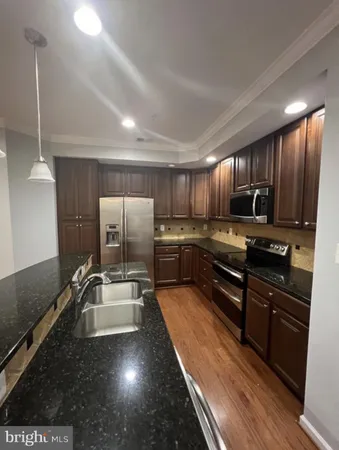 a kitchen with stainless steel appliances wooden cabinets a stove a sink and a oven