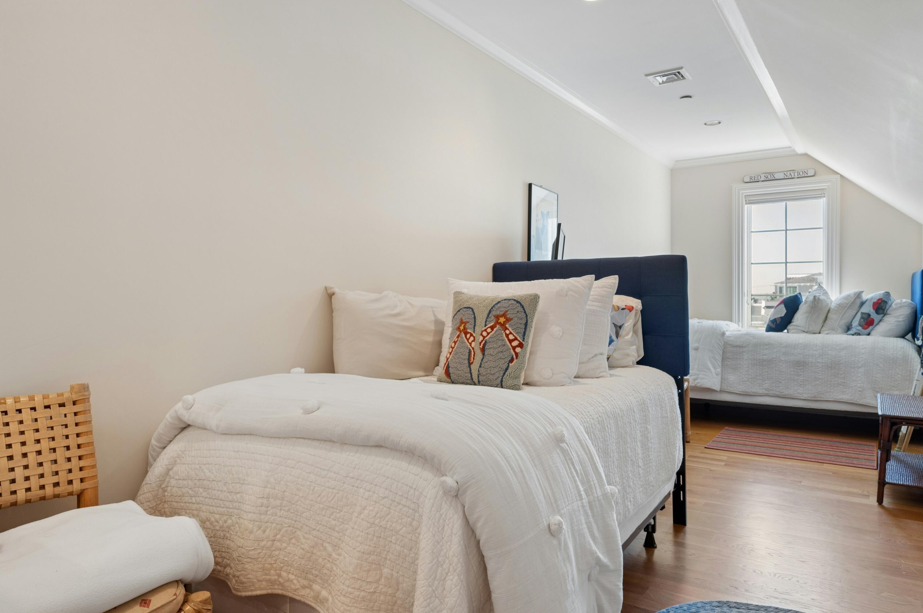 23 Snow Inn Road, Unit 7 Harwich Port, MA 02646 - Photo 33 of 37 a bedroom with a bed and wooden floor
