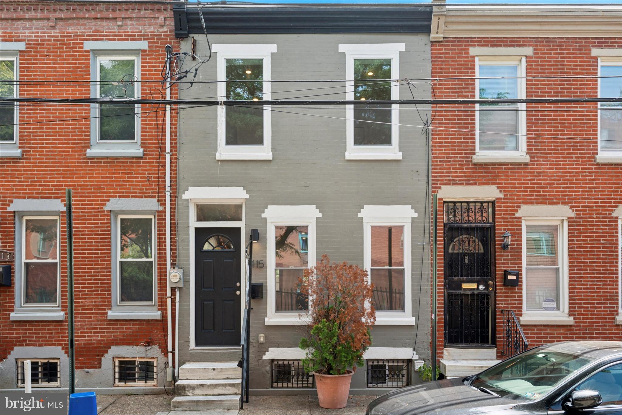 a front view of a building with a garden and windows