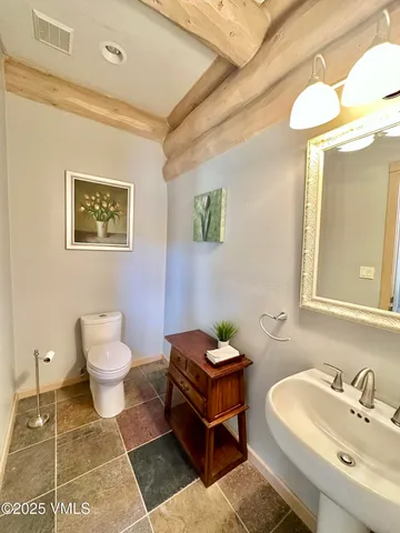 a bathroom with a toilet sink and mirror